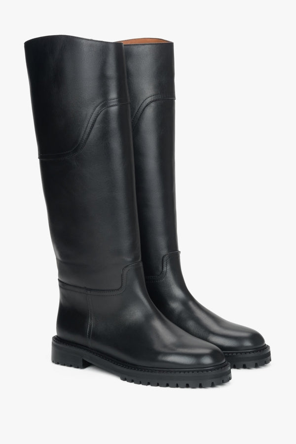 Women's tall black boots made of genuine leather with a flat sole.