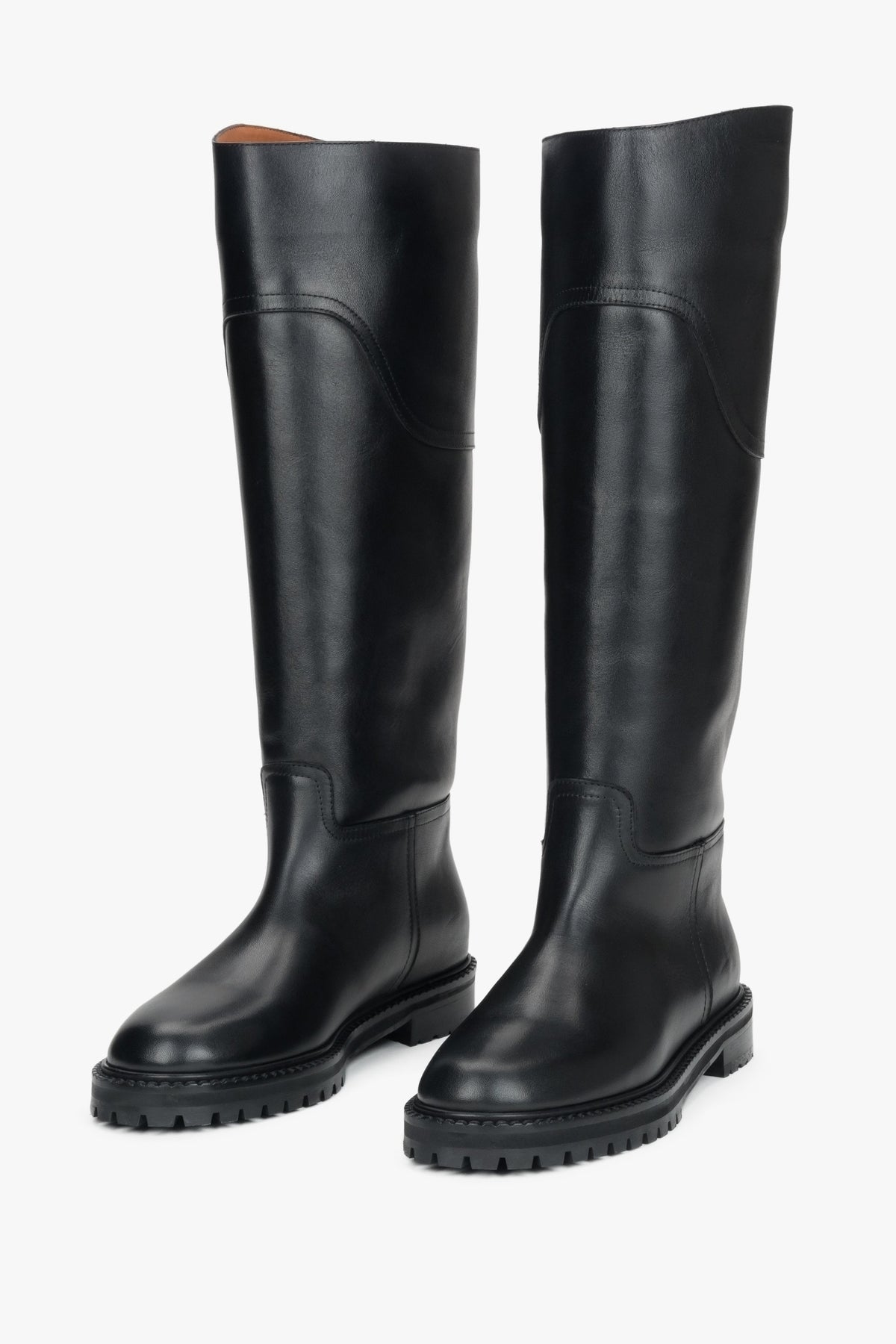 A pair of women's tall black flat boots crafted from genuine natural leather.
