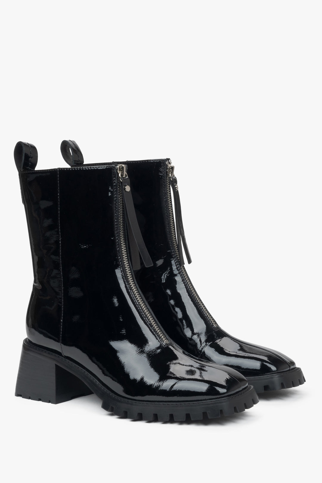 Elegant women's black ankle boots made of genuine patent leather with a low heel by Estro - close-up of the toe and side line of the shoes.