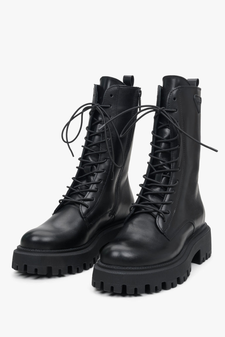 Women's tall black leather combat boots by Estro - close-up of the shoe's toe and decorative lacing system.