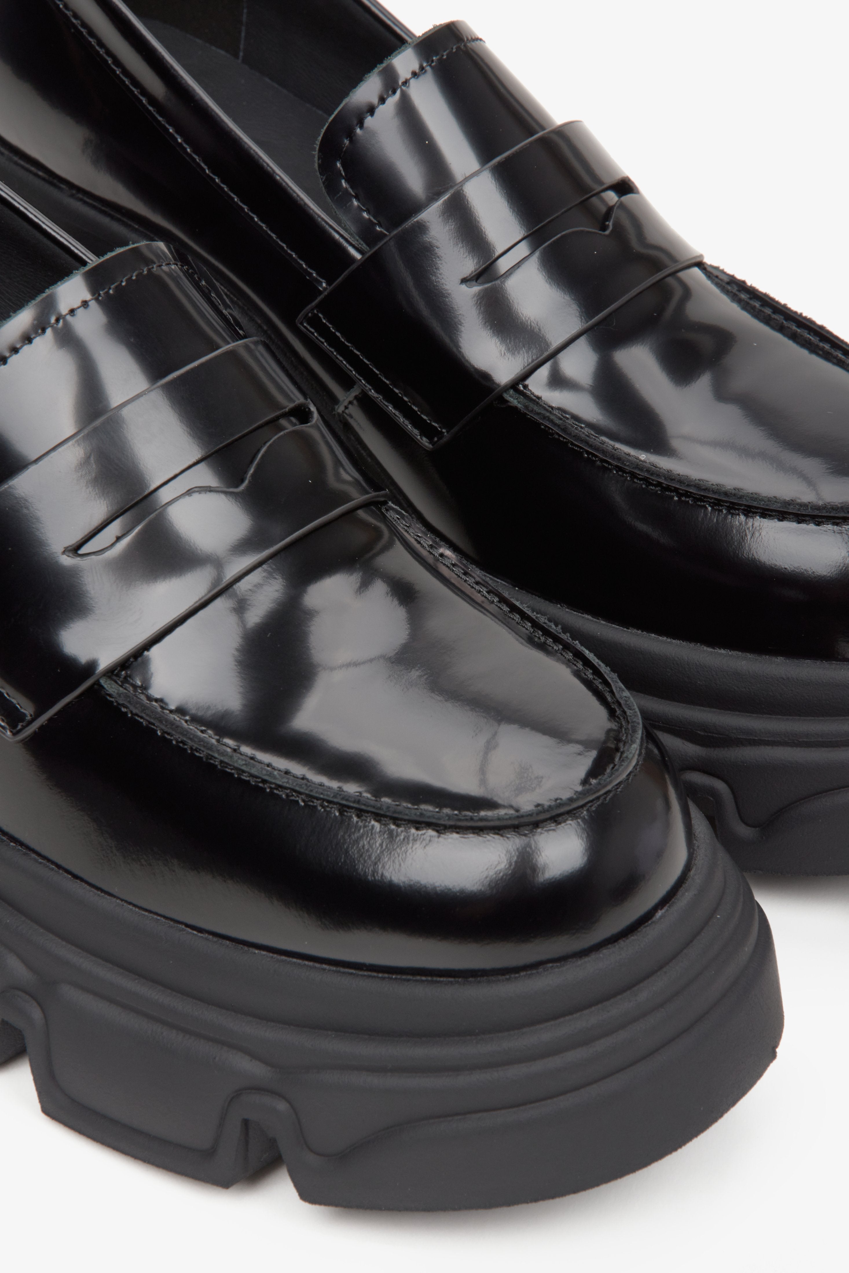 Women's black leather moccasins with a thick sole by Estro - close-up on details.