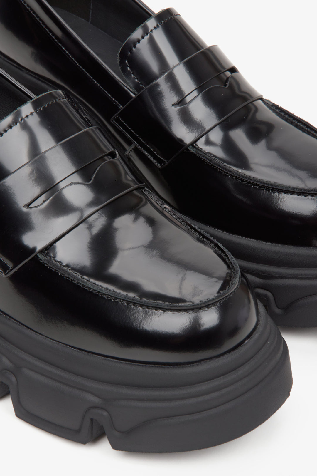 Women's black leather moccasins with a thick sole by Estro - close-up on details.