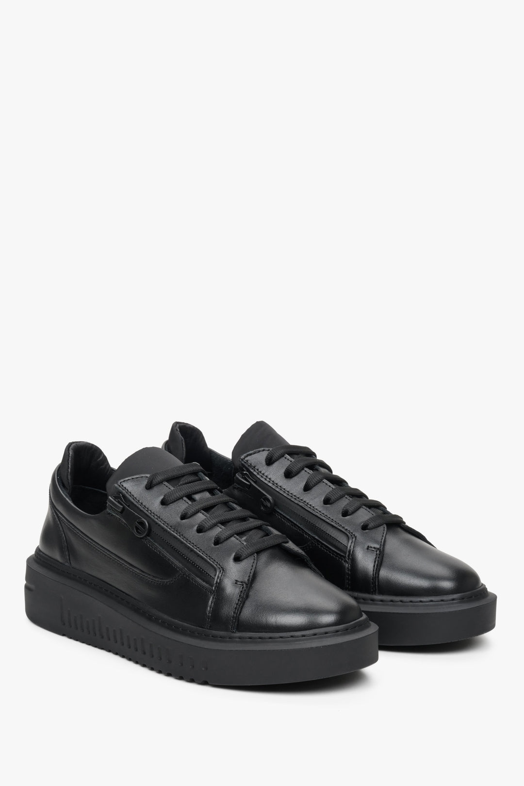 Leather, women's black sneakers by Estro with laces and decorative zipper - presentation of the shoe's toe and side seam.