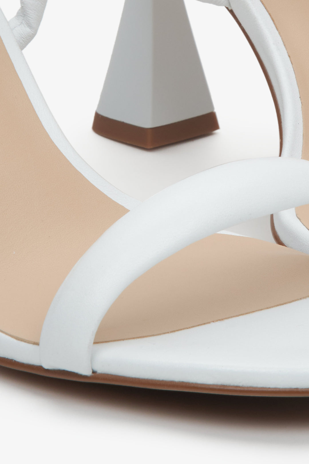 Women's white strappy sandals on a funnel heel, Estro brand. Close-up on details.
