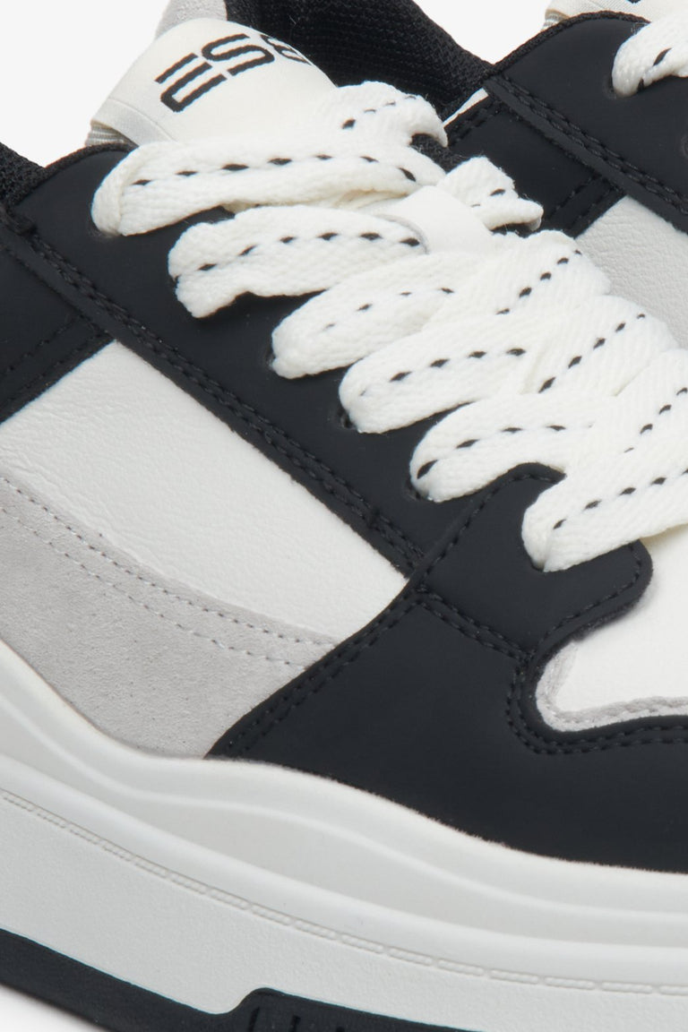 Sophisticated women's white and black leather sneakers - close-up on details.