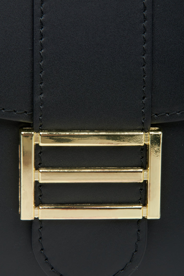 Women's black horseshoe-shaped handbag by Estro with gold accents - close-up of the details.