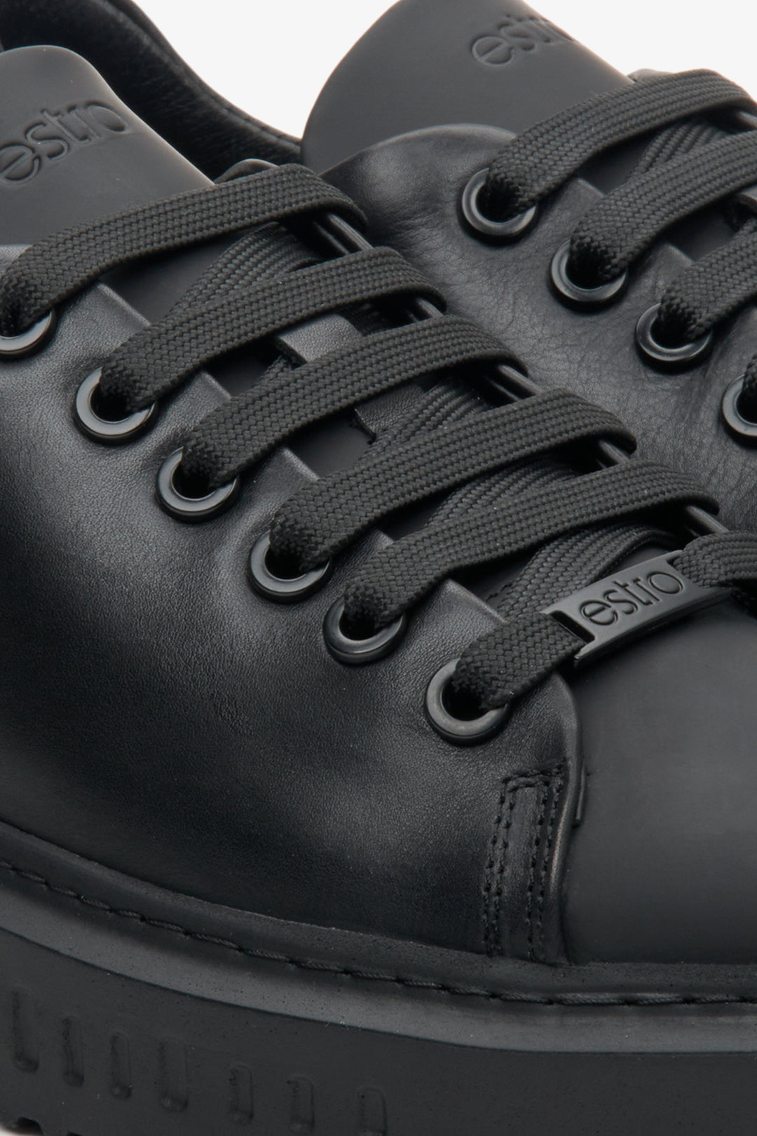 Women's black Estro sneakers with laces made from genuine leather - close-up on the details.