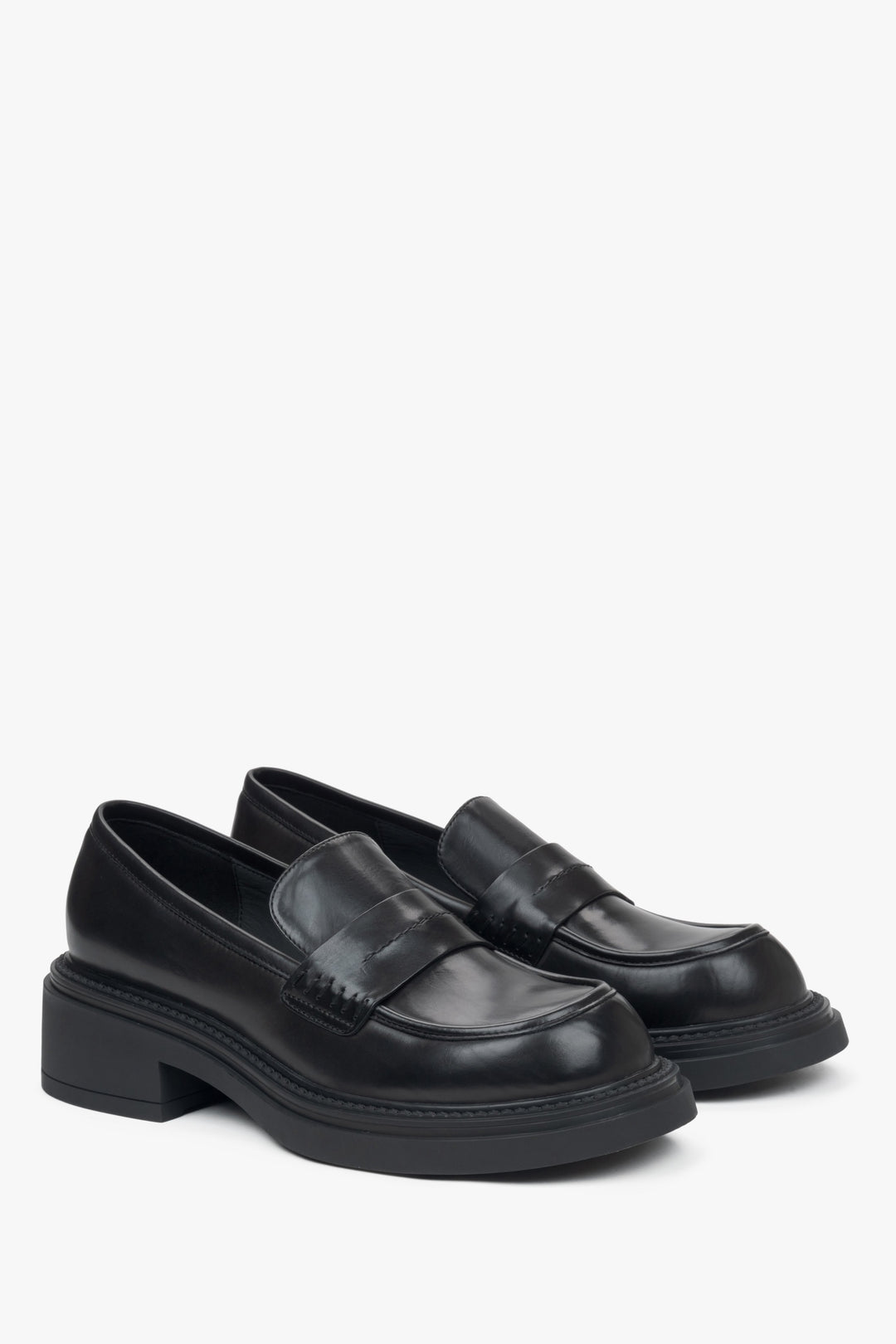 Elegant black penny loafers with a square heel from Estro - close-up of the side line of the shoes and the toe.