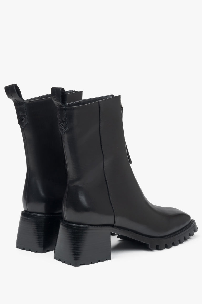 Women's black ankle boots made of genuine leather with a low heel by Estro - close-up of the heel and side line of the shoes.