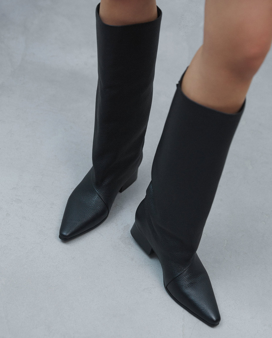 Women's black leather boots with a wide shaft by Estro - model in a complete ensemble.