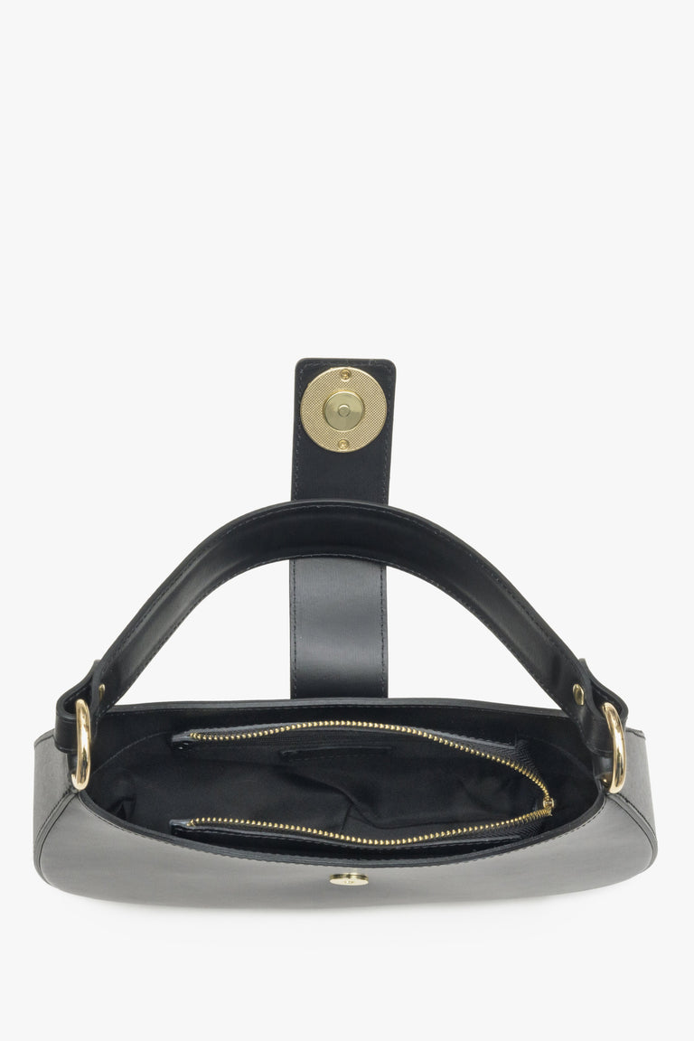 Interior presentation of a black leather baguette-style women's handbag.