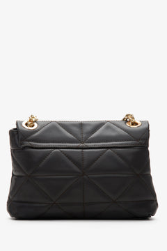 A small dark brown Estro women's handbag made from natural leather with quilting and a gold chain - close-up on the back of the model.