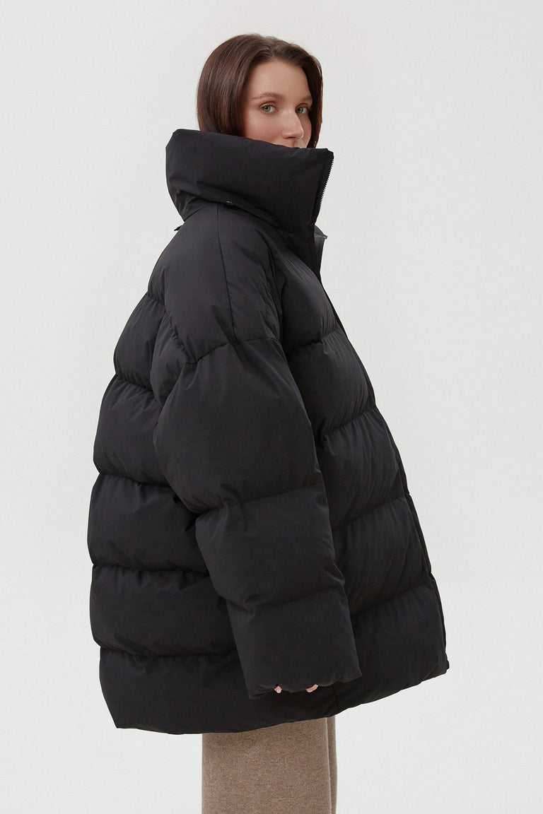 Women's black puffer jacket by Estro - side view presentation.






