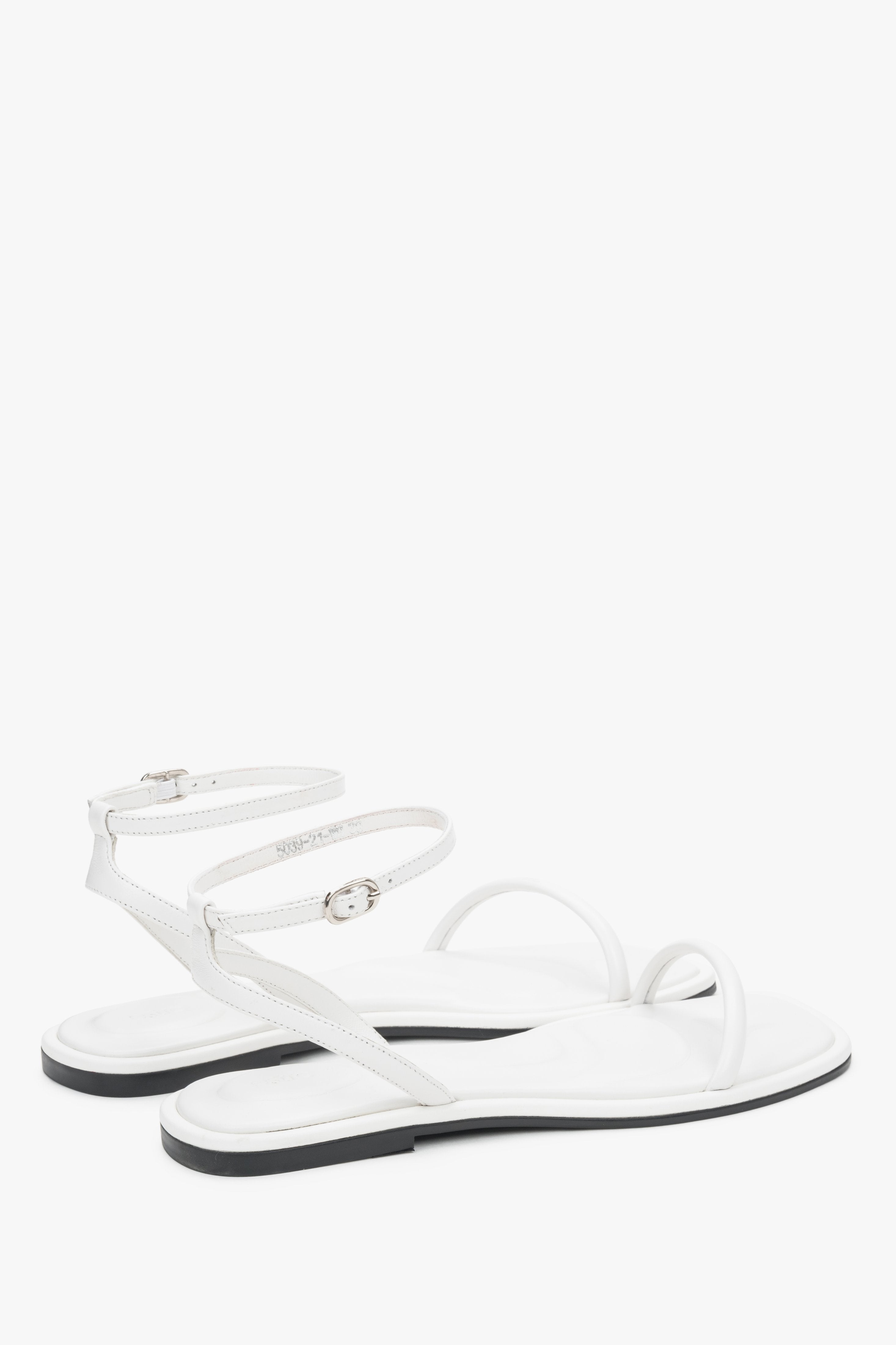 Minimalist white sandals made of genuine leather with thin straps, designed for comfort.