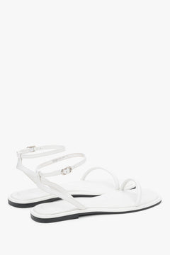 Minimalist white sandals made of genuine leather with thin straps, designed for comfort.