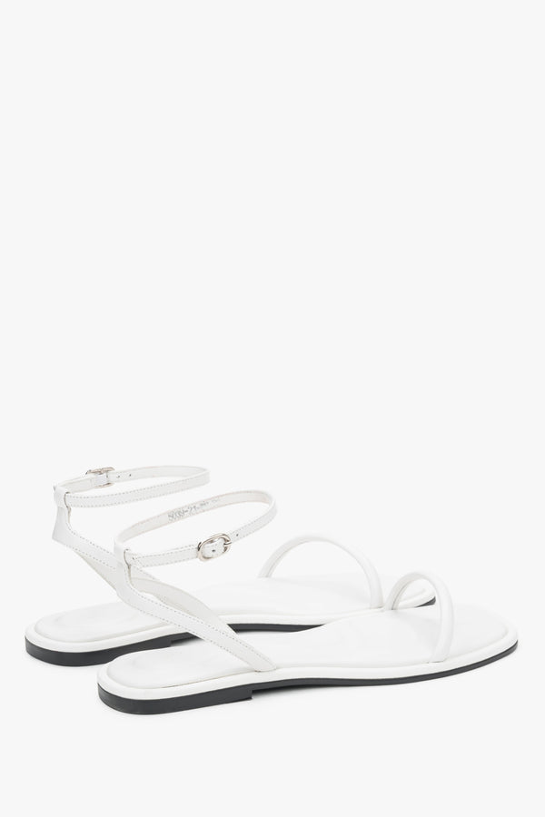 Minimalist white sandals made of genuine leather with thin straps, designed for comfort.