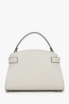 Elegant light beige satchel-style handbag designed to be carried by hand.