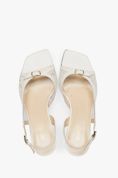 Stylish white slingback sandals with lace detailing.
