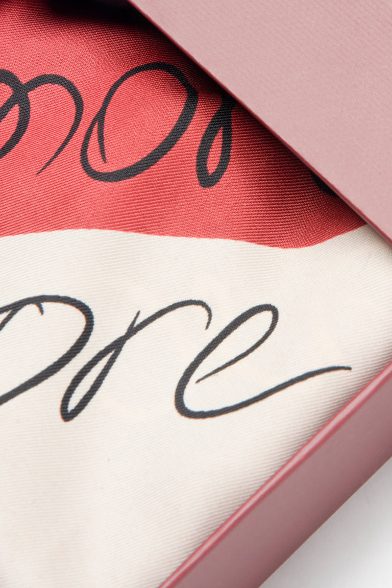 Black, beige, and red heart-patterned scarf from Estro – details.