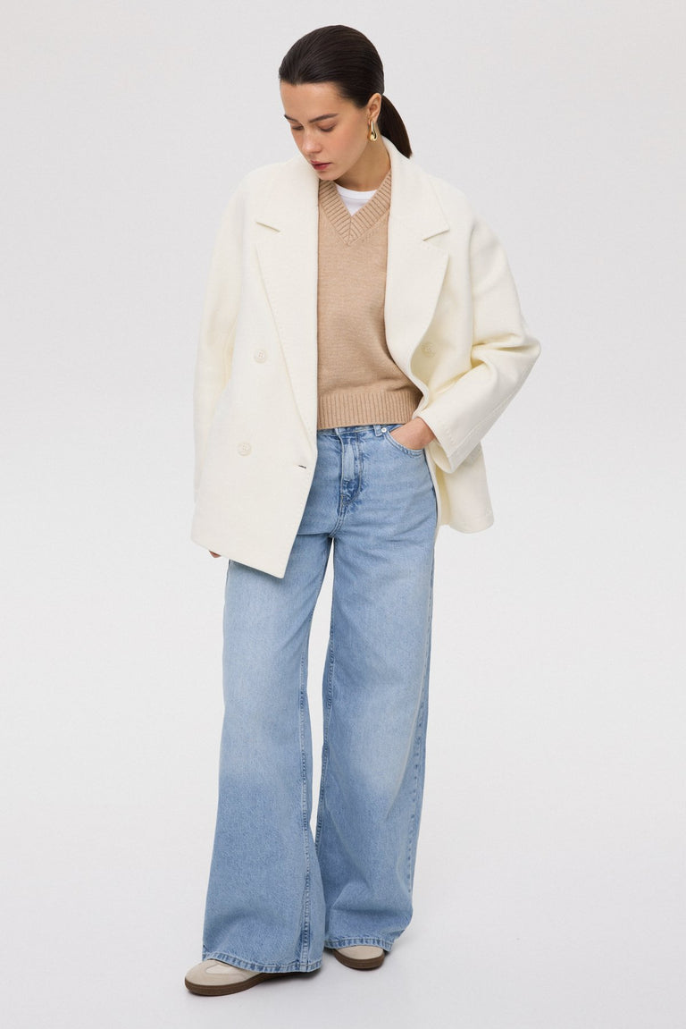 A short, woolen women's coat with a double-breasted design in an elegant white color.