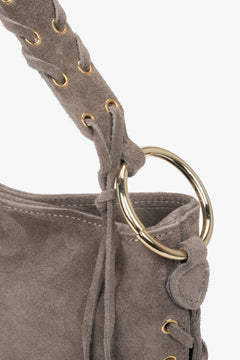 Decorative lacing and metal eyelets on the sides enhance the bag's unique boho charm.