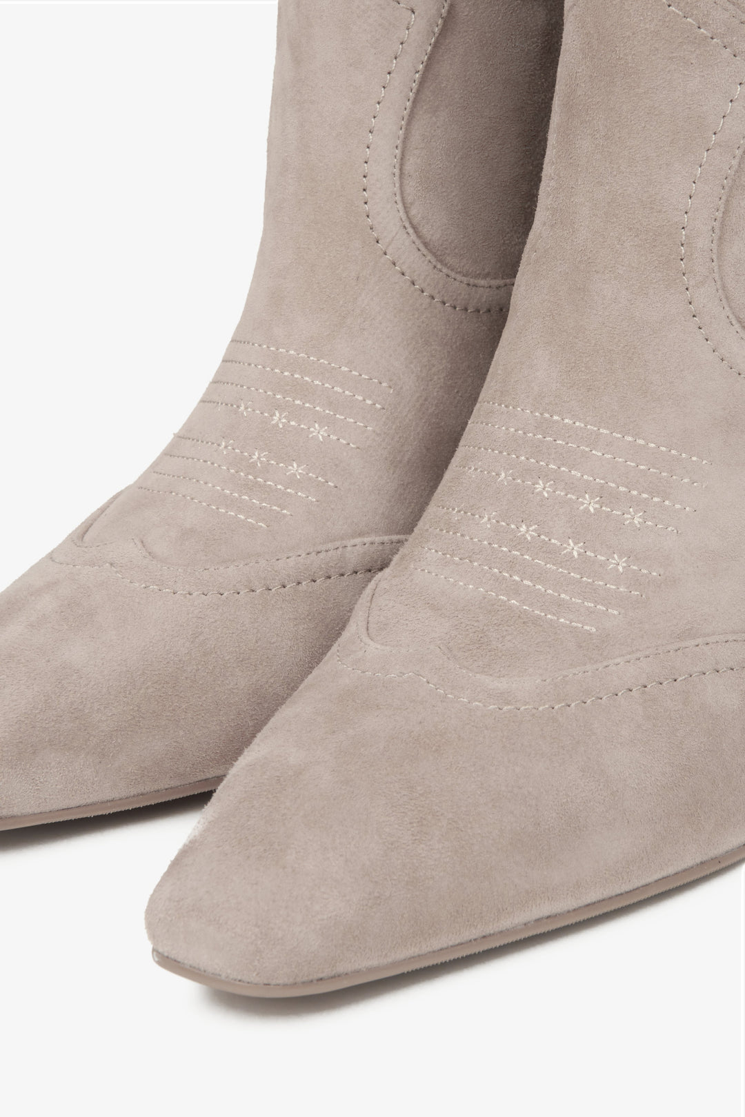 Elegant women's cowboy boots in beige natural suede with a tall shaft, crafted by Estro - a close-up on shoes' toeline.