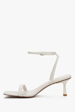 Women's beige leather sandals with square toe and buckle fastening.