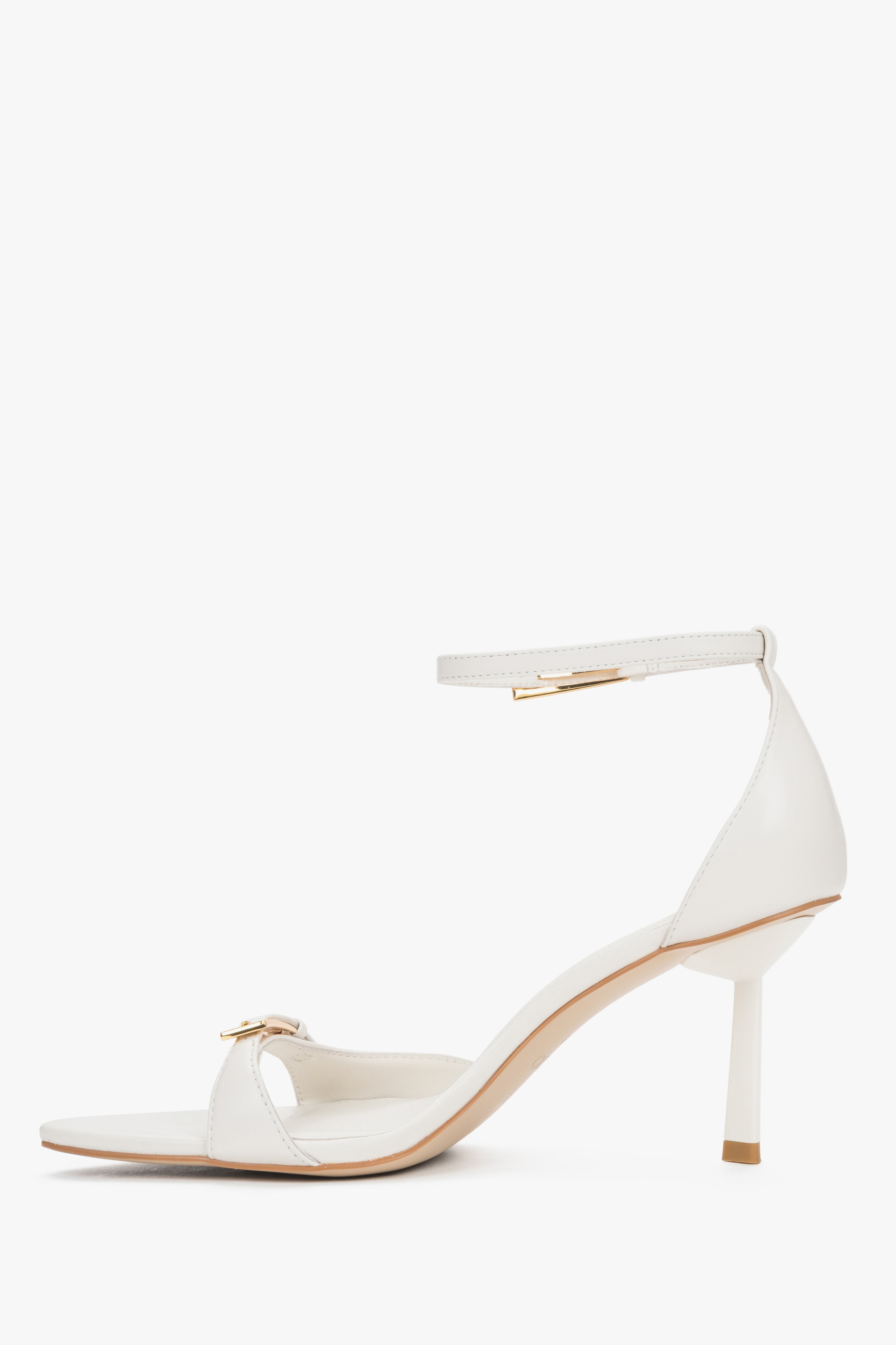 Women's beige leather sandals with decorative buckles and buckle fastening.
