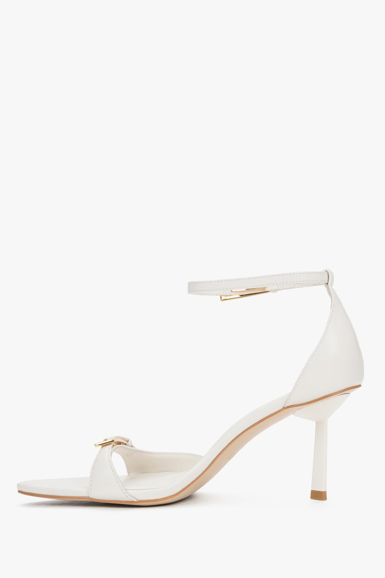 Women's beige leather sandals with decorative buckles and buckle fastening.