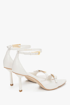 Detail view of decorative buckles on beige leather Estro sandals.