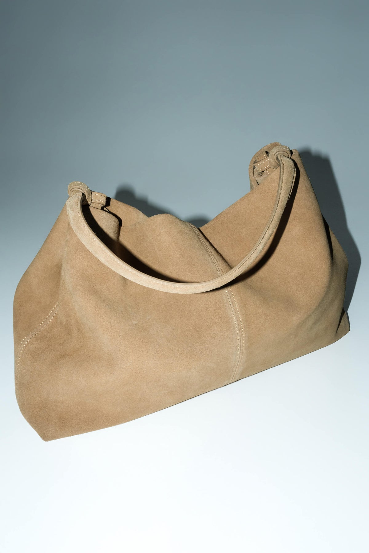 Spacious beige shopper bag with reinforced handles.