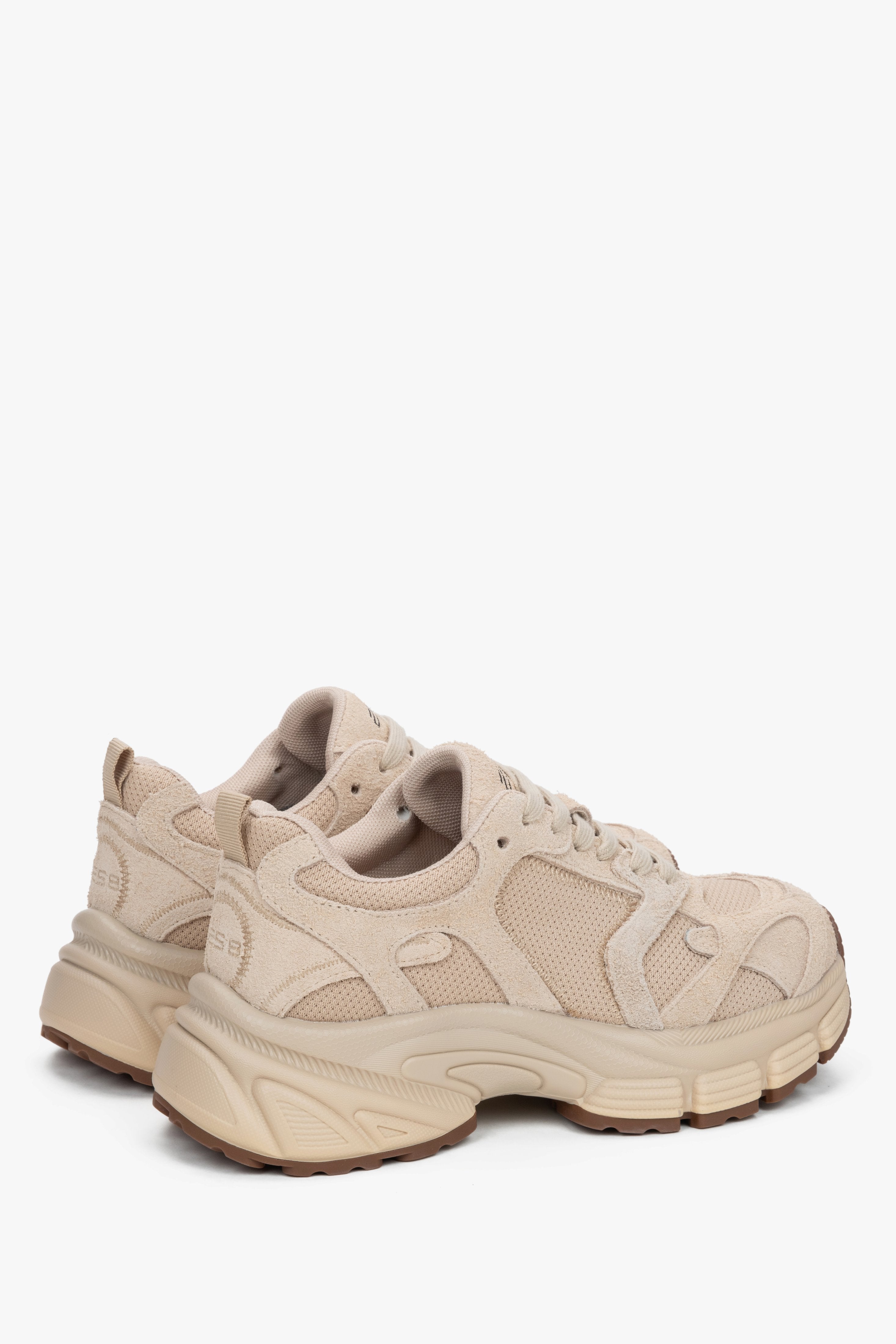 Close-up of the beige sneakers, showcasing the texture contrast between the natural velour and sporty mesh.