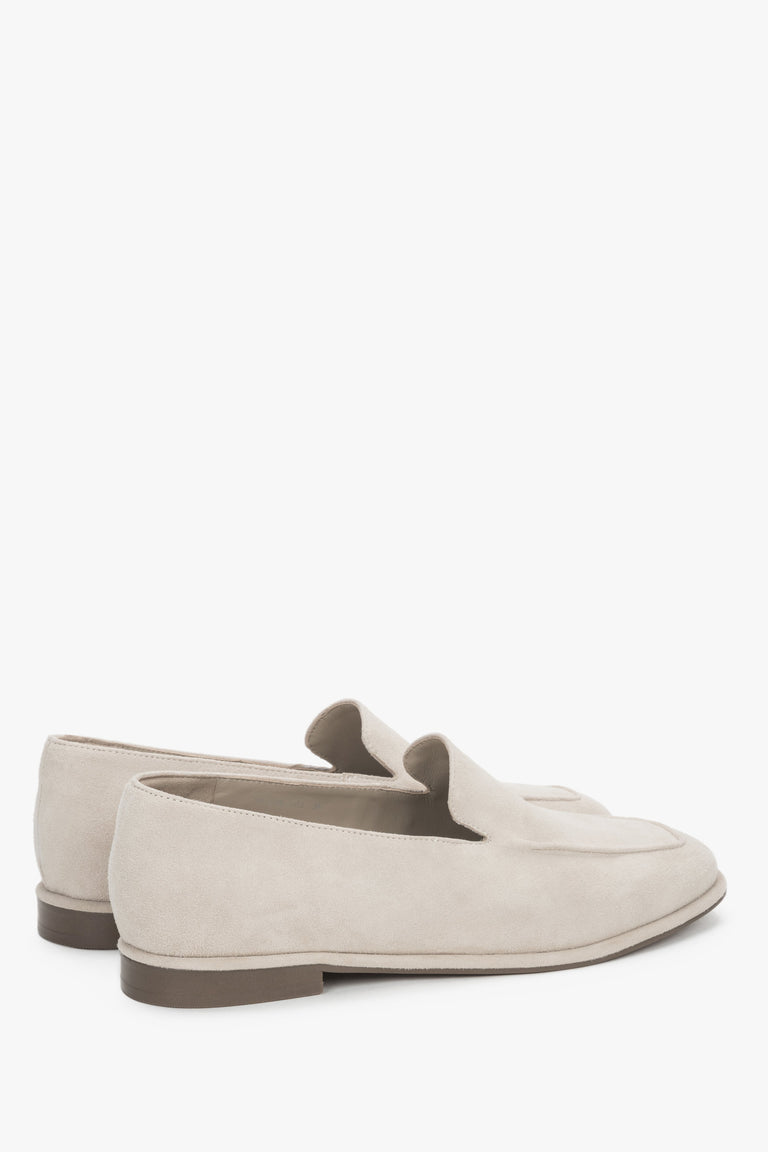 Angled view of women's beige velour loafers with decorative stitching