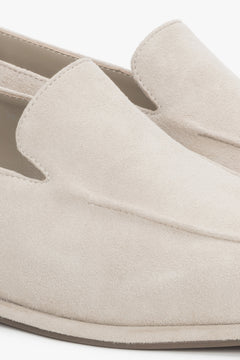 Detail view of decorative stitching on beige velour loafers by Estro