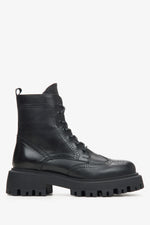 A black leather lace-up ankle boot with a chunky lug sole and brogue detailing, shown from a side profile.