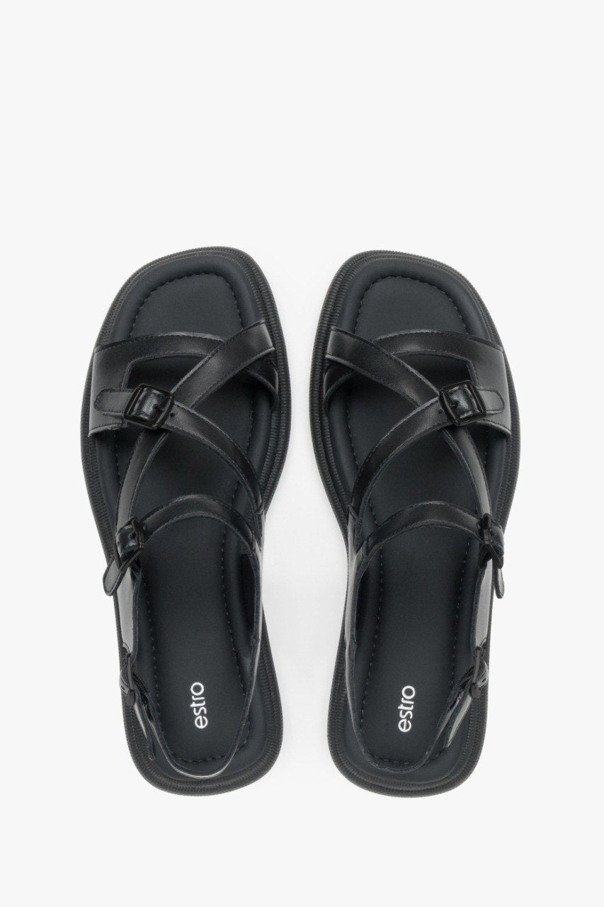 Minimalist women’s black leather sandals on a flat sole with black accents