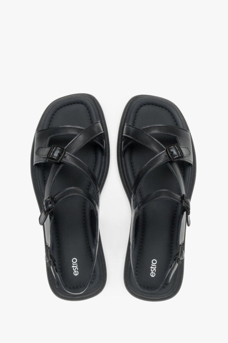 Minimalist women’s black leather sandals on a flat sole with black accents