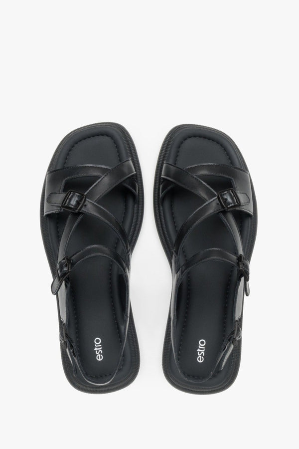 Minimalist women’s black leather sandals on a flat sole with black accents