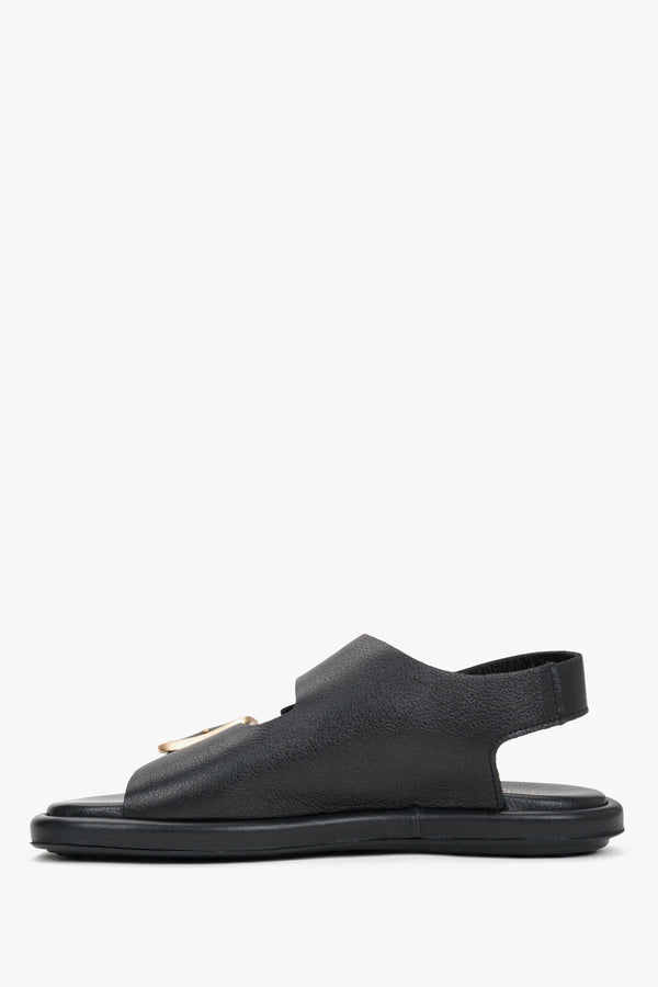 Black women’s flat sandals with adjustable gold-tone buckles by Estro.