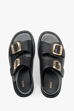 Black women’s flat sandals with adjustable gold-tone buckles, Estro.