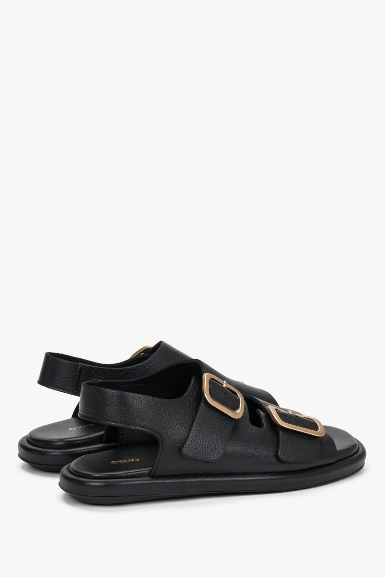 Black women’s Estro flat sandals with adjustable gold-tone buckles.