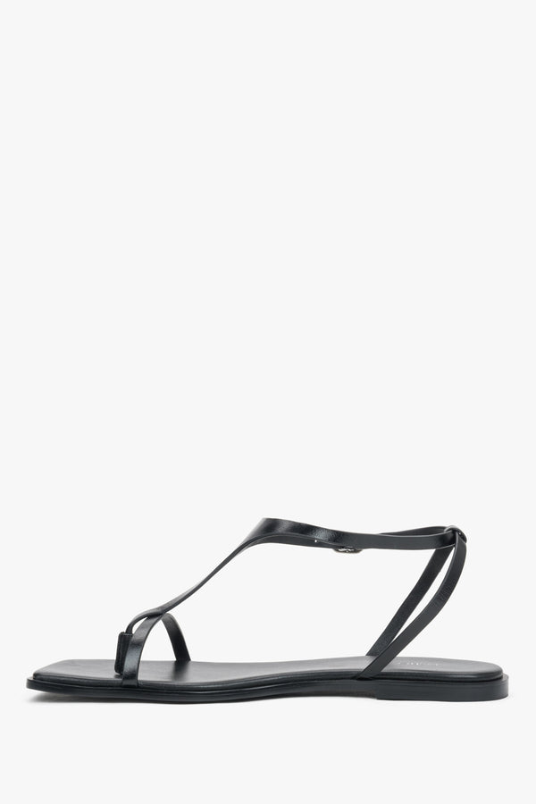 Women’s black flat sandals with a square toe and toe-post strap by Estro – side view.