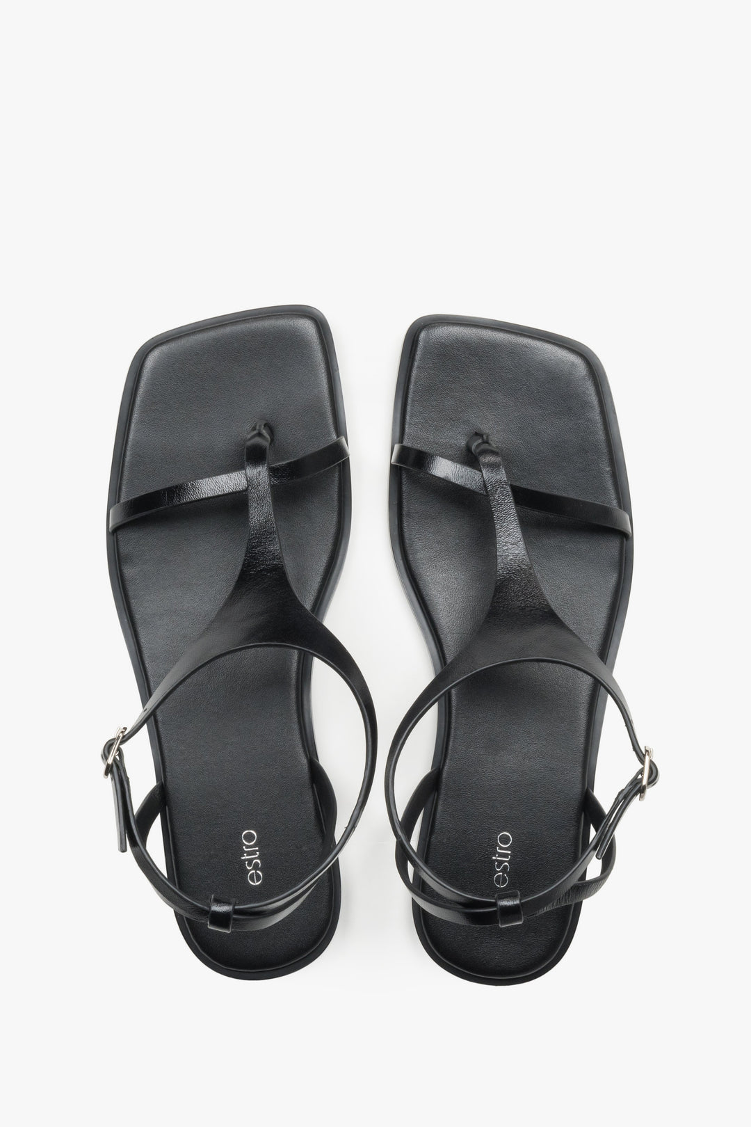 Women’s black flat sandals with a square toe and toe-post strap by Estro.