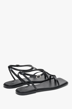 Women’s black flat sandals by Estro with a square toe and a toe-post strap.