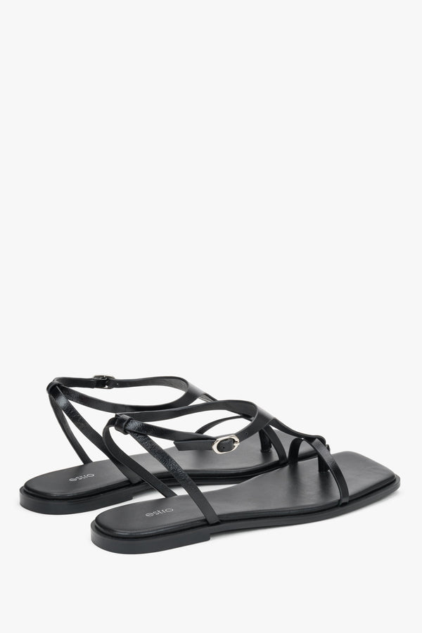 Women’s black flat sandals by Estro with a square toe and a toe-post strap.