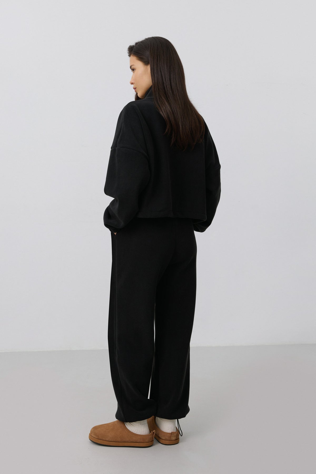 Women's black fleece tracksuit set Estro - back view highlighting the comfortable cut and hooded detail.