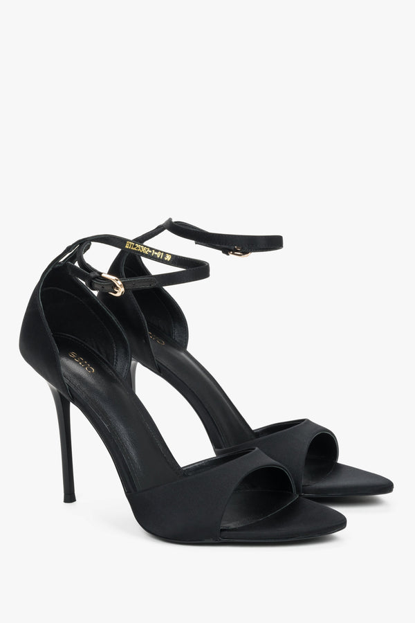 Angled view of women's black high heel sandals with feather trim