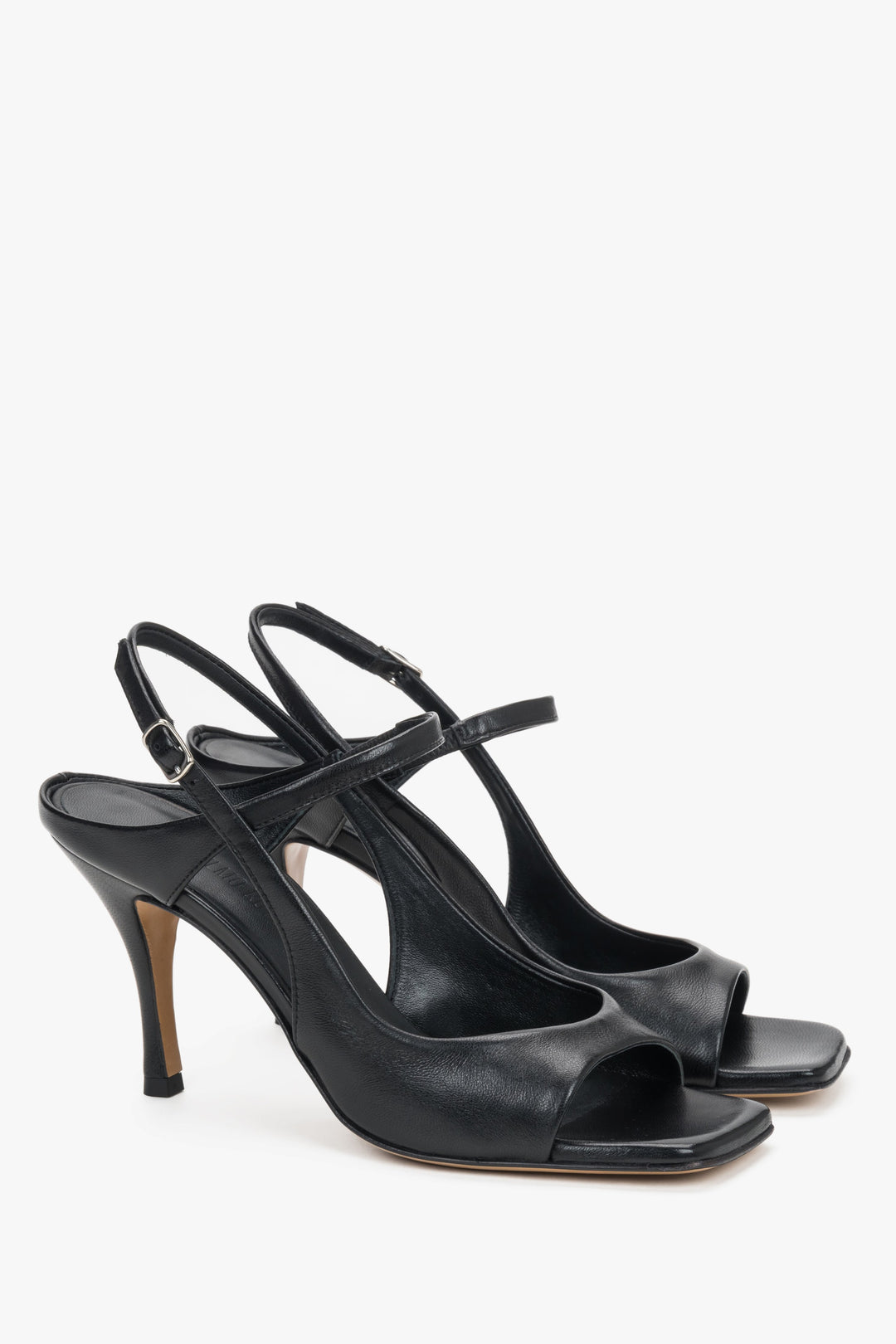Elegant black stiletto sandals featuring a stabilizing strap and adjustable ankle buckle.
