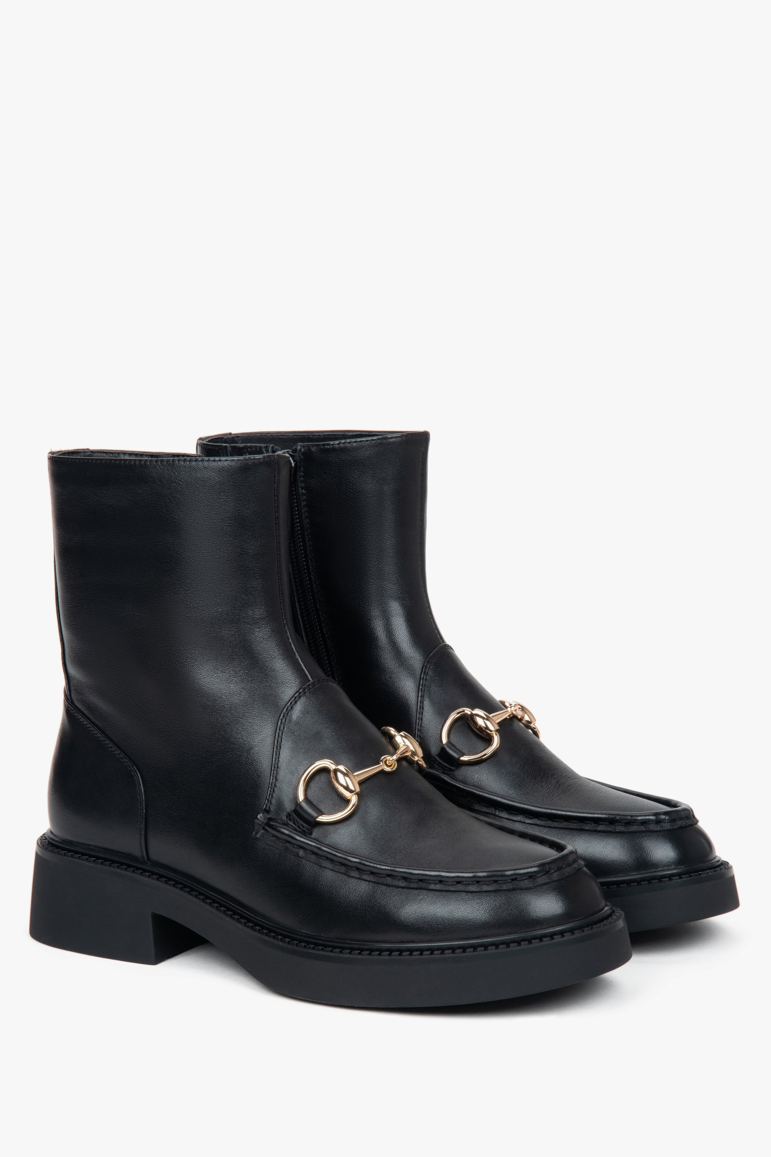 Women’s black leather ankle boots with a decorative buckle by Estro.