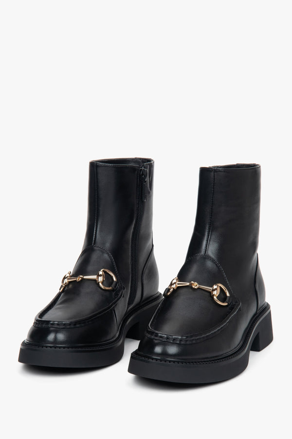 With a decorative buckle, black women’s leather ankle boots by Estro.